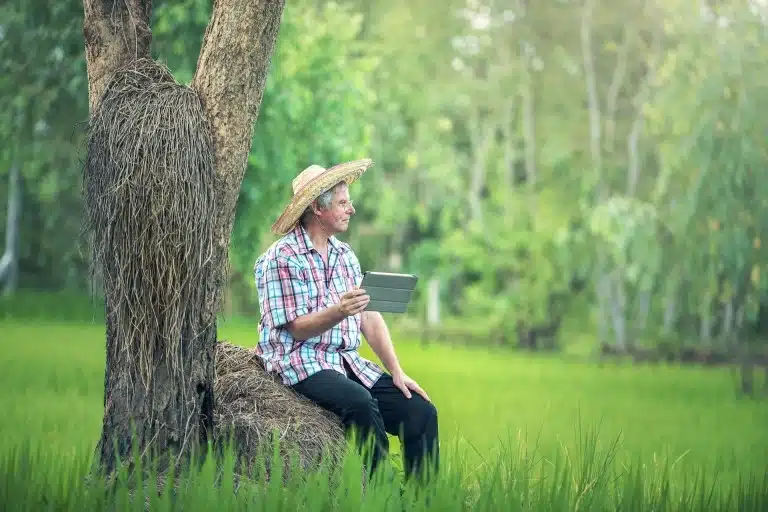 Person wearing hat using tablet outdoors